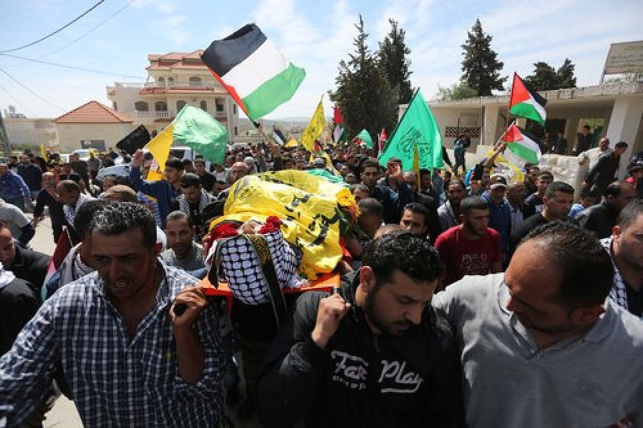In March 2016 in the West Bank village of Deir Debwan, Palestinian mourners chant slogans while carrying the body of Mahmoud Shalan, a Palestinian-American terrorist who had tried to murder Israelis before security forces killed him. Credit: Photo by Flash90.