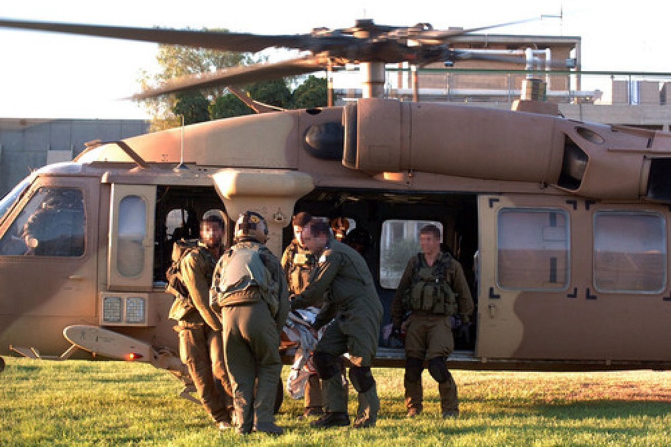 IDF soldiers rush injured Israelis to Soroka Hospital in Beersheva after evacuating them by helicopter on Aug. 26, 2014, following a mortar attack on Kibbutz Nirim near the Gaza border. Two Israeli men died from wounds they sustained in the incident, which took place shortly before the latest Israel-Hamas ceasefire deal went into effect. Photo by Flash90.