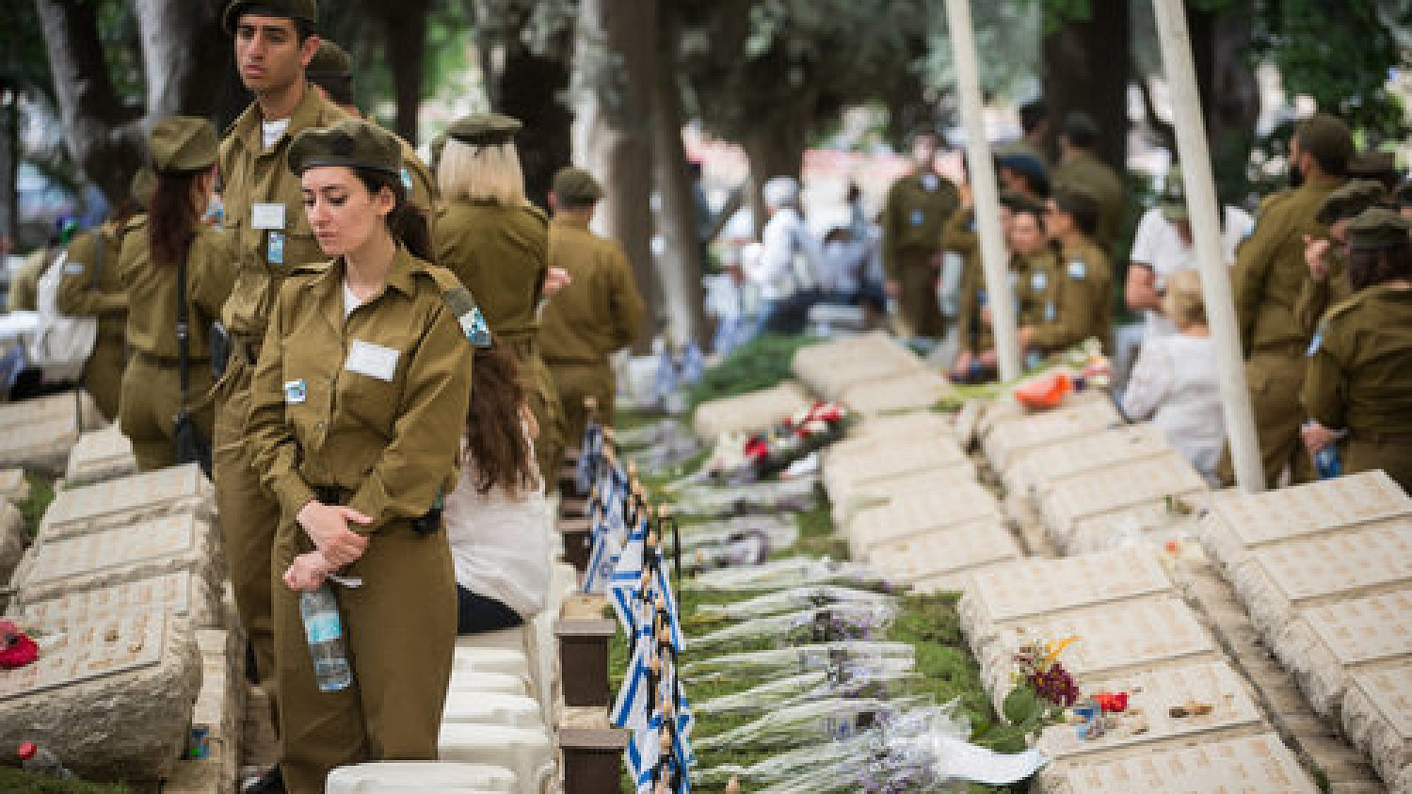 Israeli soldiers stand by the graves of the fallen at the Kiryat Anavim military cemetery on Yom Hazikaron (Memorial Day), on May 1, 2017. Credit: Hadas Parush/Flash90.