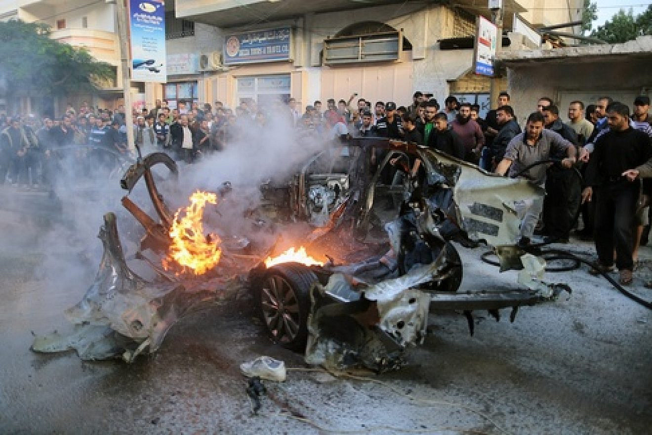 Click photo to download. Caption: People look at a wreckage of the car in which Ahmed Jabari, head of the Hamas's military wing, was killed by an Israeli air strike in Gaza City on Nov. 14. Credit: Wissam Nassar/FLASH90.