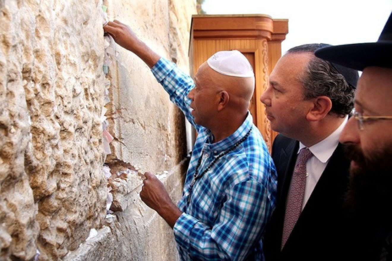 Hip-hop mogul Russell Simmons places a note in the Western Wall during his recent trip to Israel. Behind him is his partner for Muslim-Jewish dialogue work, New York Rabbi Marc Schneier. Photo by Sasson Tiram.