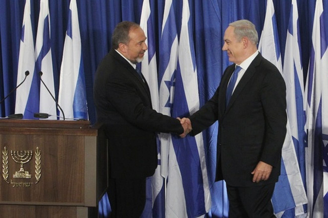 Click photo to download. Caption: Prime Minister Benjamin Netanyahu of the Likud party (R) and Foreign Minister Avigdor Lieberman of the Yisrael Beiteinu party shake hands at a joint press conference Oct. 25 announcing that the two parties are joining forces ahead of the upcoming Israeli general elections. Credit: Miriam Alster/FLASH90.