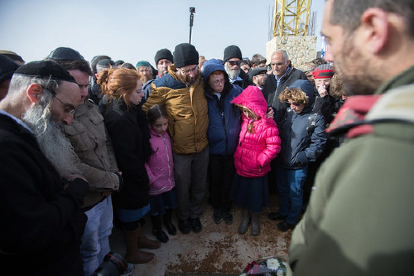Click photo to download. Caption: In center, the husband and children of Israeli victim of terror Dafna Meir look down at her fresh grave during her funeral in Jerusalem on Jan. 18. Credit: Yonatan Sindel/Flash90.