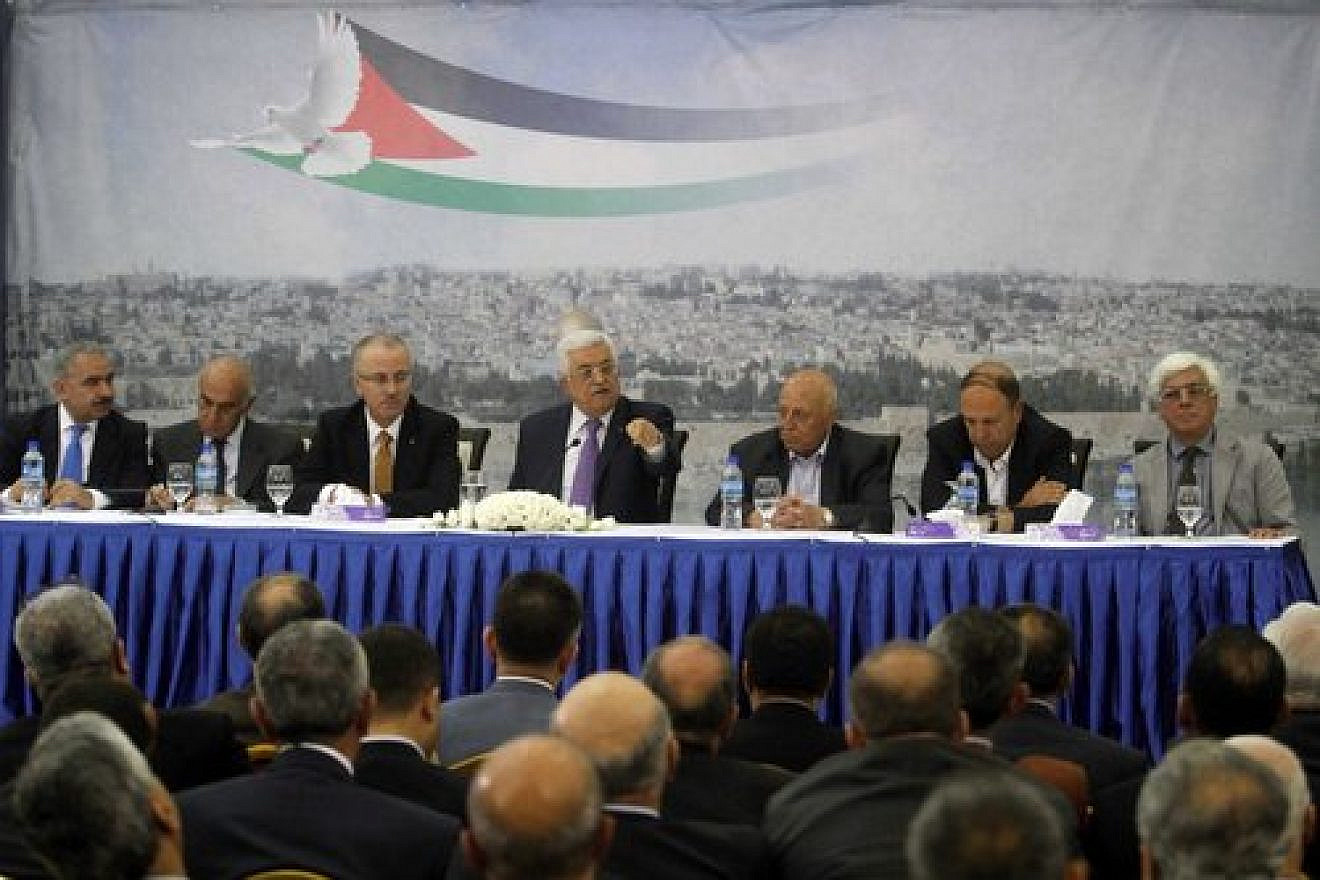 Palestinian Authority leader Mahmoud Abbas (center) attends a meeting of Palestinian businessmen in Ramallah April 29, 2014. The Palestinian National Fund, often in partnership with the P.A., pays salaries to imprisoned Palestinian terrorists and their families. Credit: Issam Rimawi/Flash90.