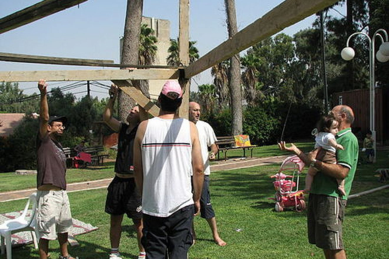 The construction of a sukkah in Ramat Hacovesh, Israel. One possible advantage of renting a sukkah over owning one is avoiding the process of putting up and taking down the sukkah yourself. Credit: PikiWiki - Israel free image collection project.