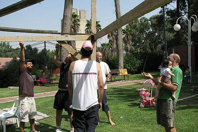 The construction of a sukkah in Ramat Hacovesh, Israel. One possible advantage of renting a sukkah over owning one is avoiding the process of putting up and taking down the sukkah yourself. Credit: PikiWiki - Israel free image collection project.