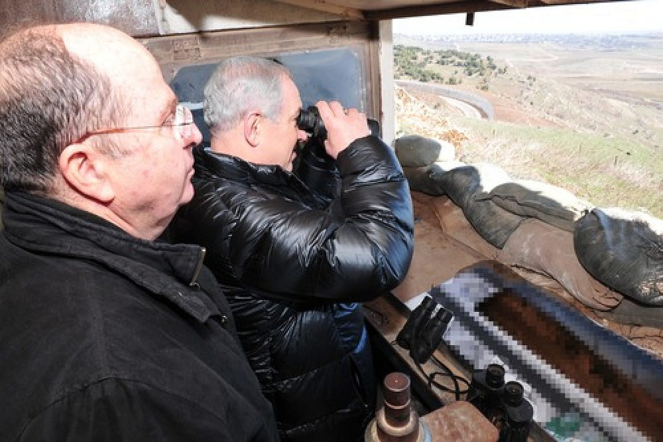 Israeli Minister of Defense Moshe Ya'alon (left) and Prime Minister Benjamin Netanyahu (center, with binoculars) survey the Israeli-Syrian border in the strategically significant Golan Heights region on Feb. 18, 2014. Credit: Ariel Hermoni/Ministry of Defense/FLASH90.