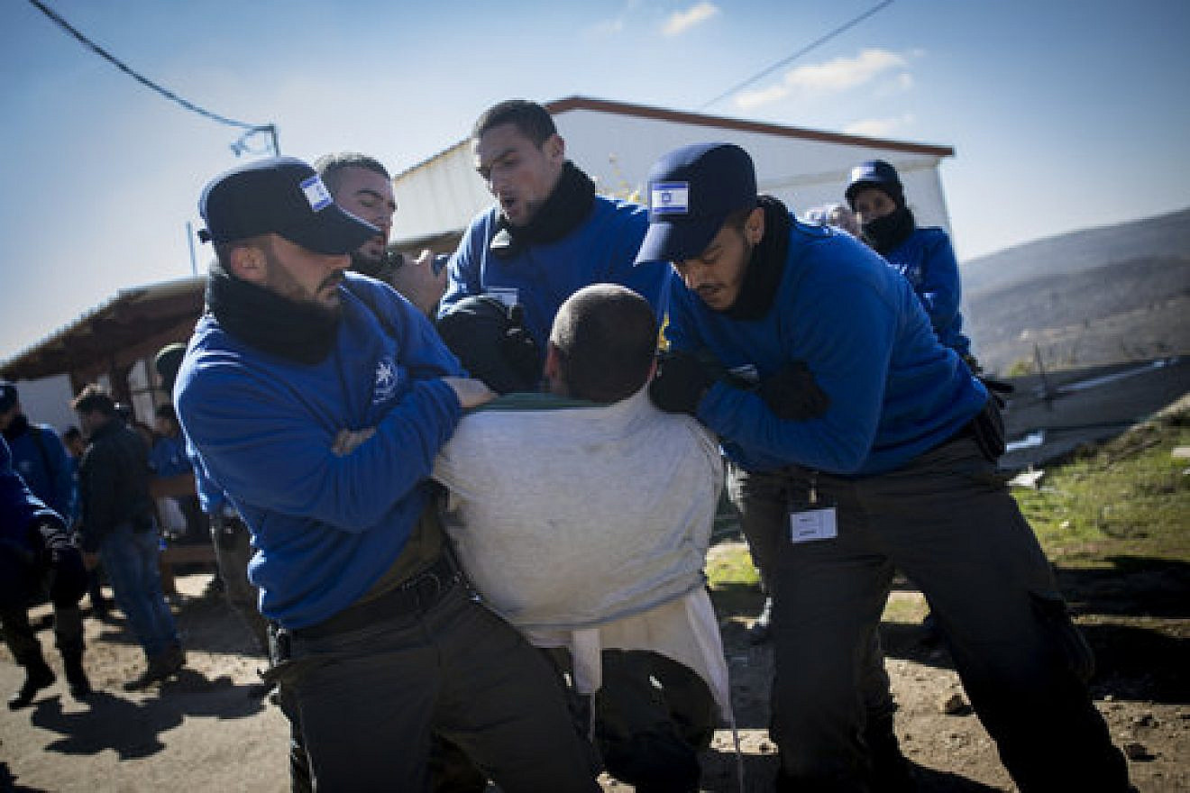 Israeli police forces carry out the evacuation of Amona as a resident resists the court-ordered process Feb. 2. Credit: Yonatan Sindel/Flash90.