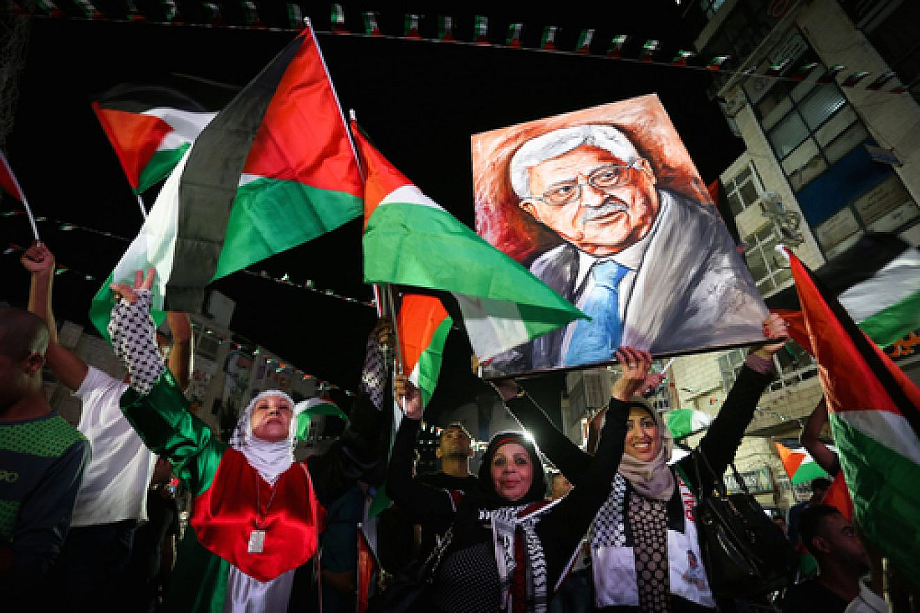 Palestinians in Ramallah wave their national flags and a picture of Palestinian Authority leader Mahmoud Abbas while they watch a live-screening of Abbas's speech at the United Nations, Sept. 30, 2015. Photo by Flash90.