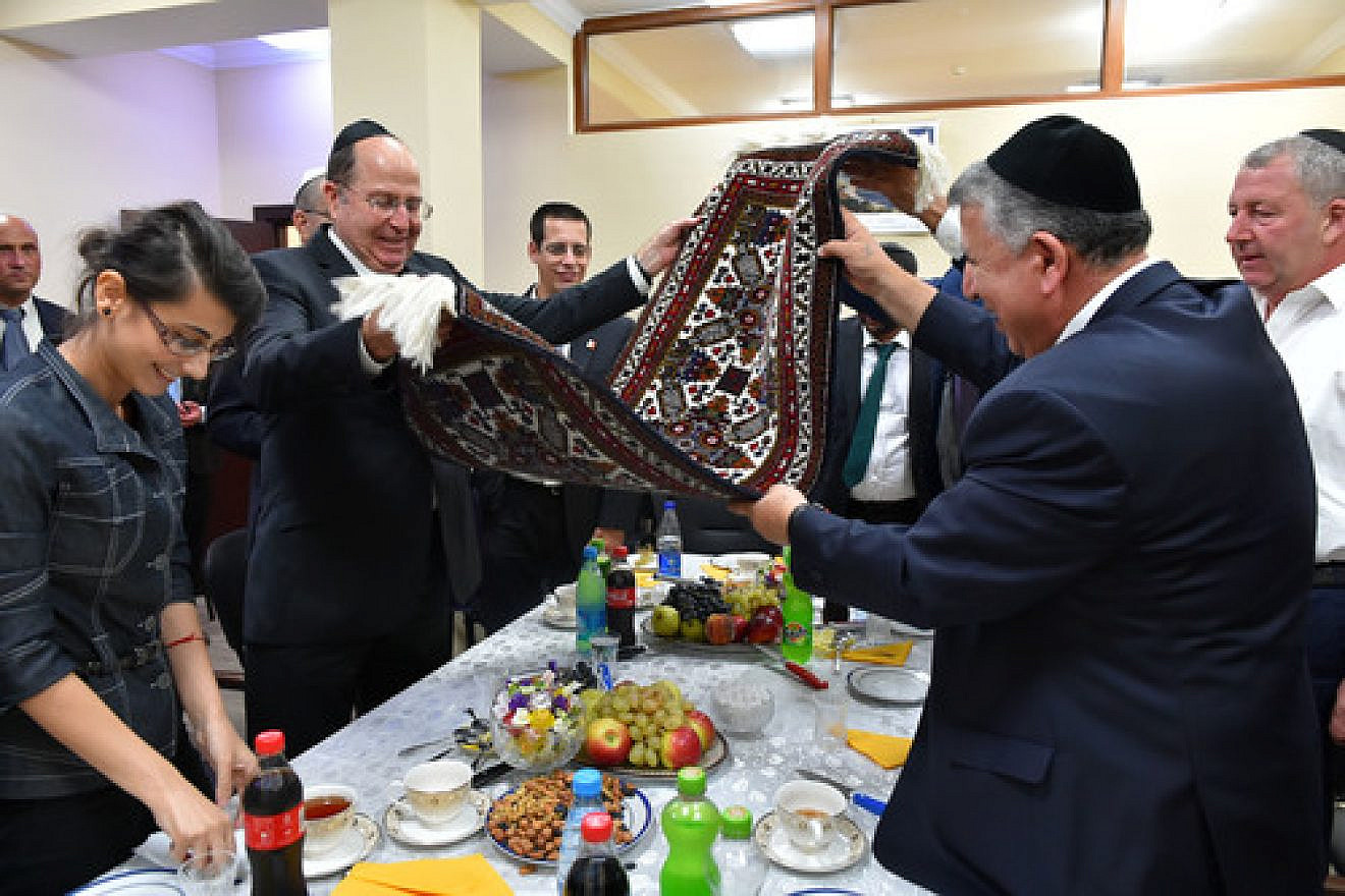 Israeli Minister of Defense Moshe Ya'alon (pictured at left, in center, holding rug) meets with representatives from the Jewish community in Baku, Azerbaijan's capital, on September 10, 2014. Credit: Ariel Hermoni/Ministry of Defense/Flash90.