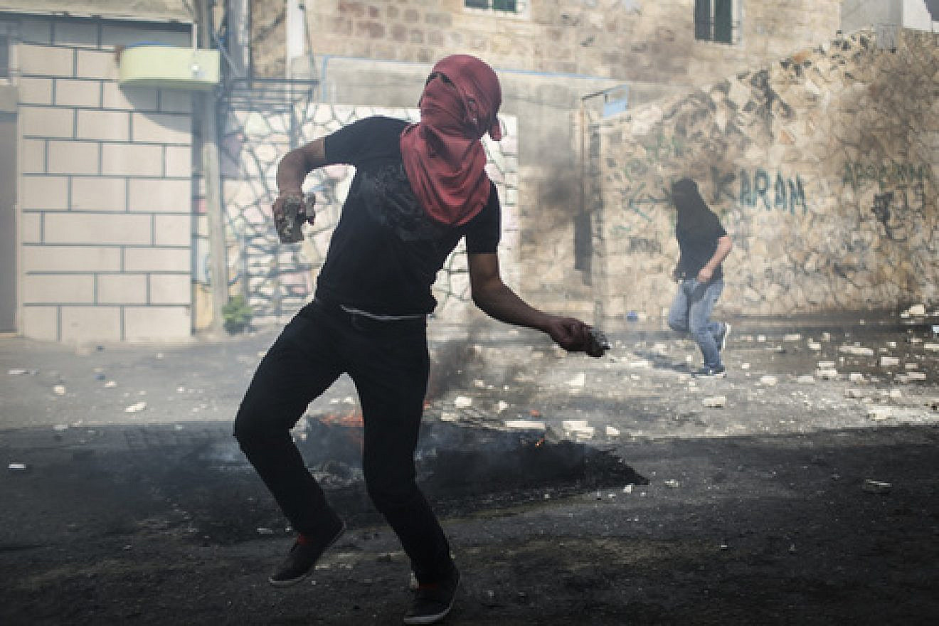 On Oct. 30, 2014, a Palestinian rock thrower targets Israeli police in Jerusalem's Abu Tor neighborhood, near the house of the Palestinian man suspected of attempting to assassinate Temple Mount activist Yehudah Glick. Credit: Hadas Parush/Flash90.