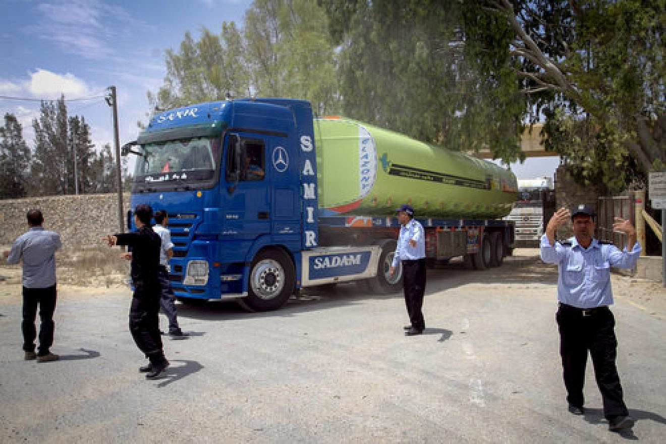 Palestinian security officers stand guard as Egyptian trucks carrying fuel drive down a street after entering the Gaza Strip from Egypt, June 21, 2017. Credit: Abed Rahim Khatib/Flash90.