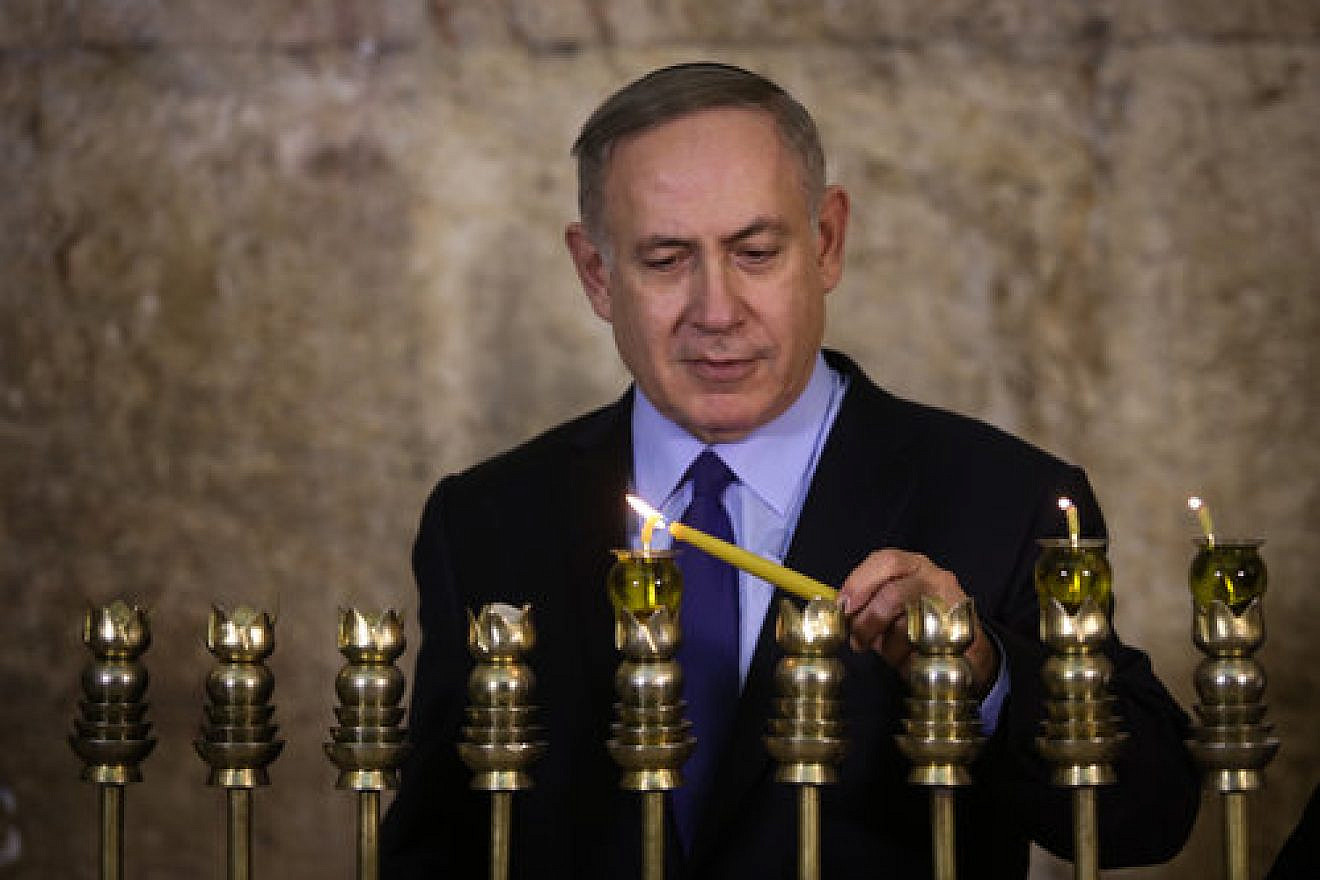 Israeli Prime Minister Benjamin Netanyahu lights a Hanukkah menorah at the Western Wall in Jerusalem, Dec. 25, 2016. Credit: Marc Israel Sellem/POOL/Flash90.