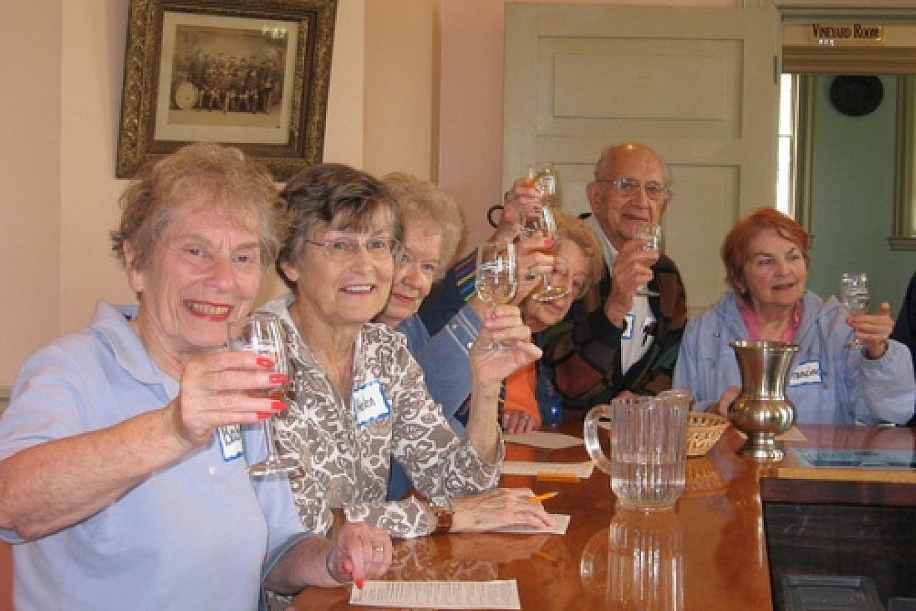 Community members make a toast at the St. Louis NORC ( Naturally Occurring Retirement Community). A group of Jewish federations started NORC communities in response to a federal initiative to develop replicable models to deal with the coming increase in the senior population. Credit: St. Louis NORC.