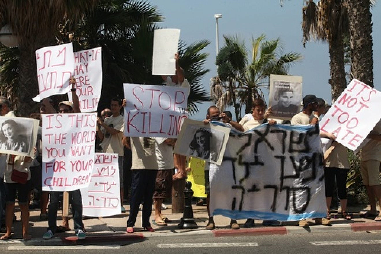 Protesters outside the Russian embassy in Tel Aviv on Aug. 30 hold placards during a demonstration against the use of chemical weapons in Syria. The U.S. and Russia, Syria's ally, on Saturday agreed to a deal stipulating that Syria must remove or destroy its chemical weapons stockpile by mid-2014. The deal tables a U.S. strike on Syria, which could have resulted in Syrian retaliation against Israel. Yet Israelis still have long-term concerns about Syria. Credit: Roni Schutzer/Flash90.