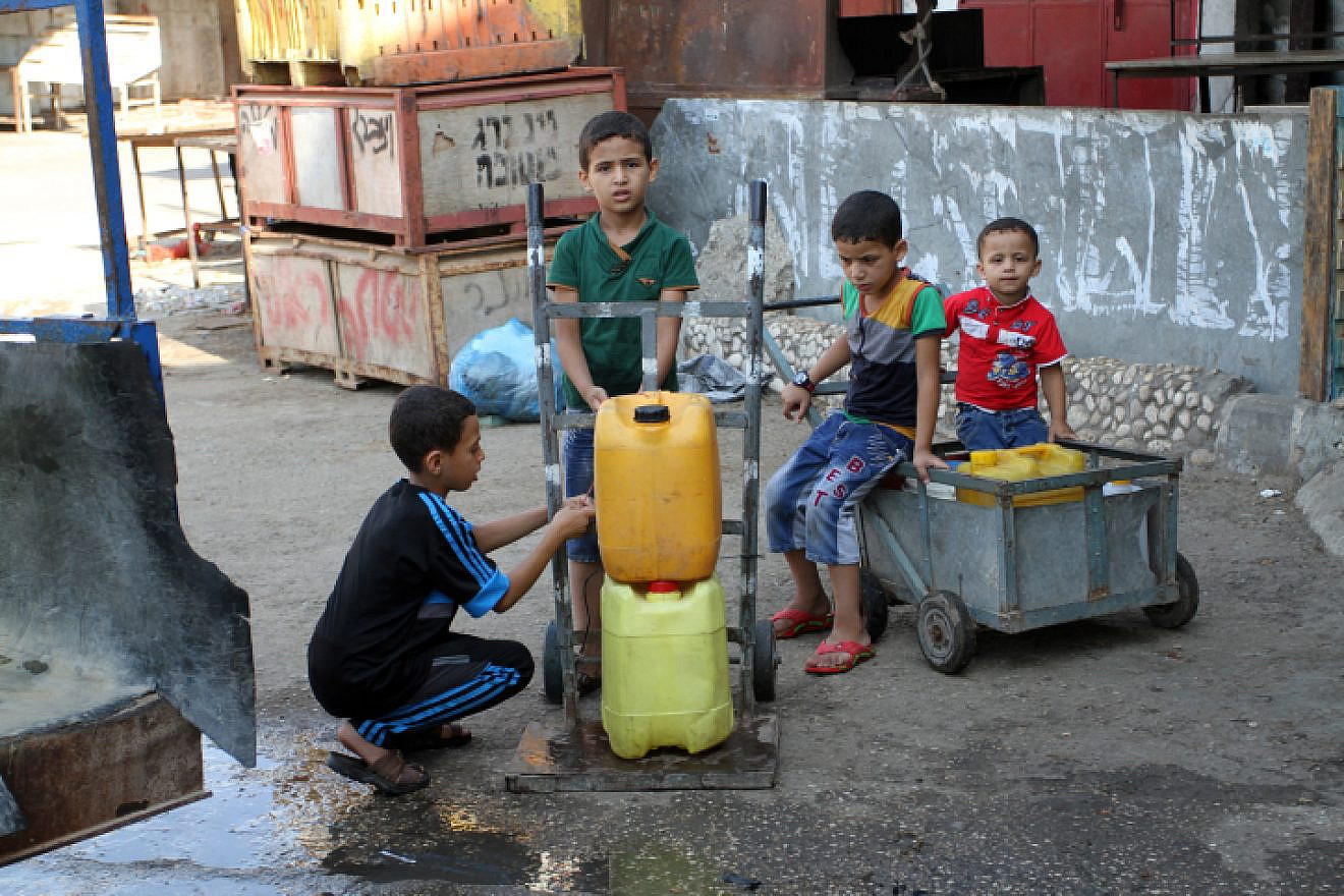 Palestinians fill plastic bottles with drinking water from a public tap in the southern Gaza Strip refugee camp of Rafah, on July 26, 2015. Photo by Abed Rahim Khatib/Flash 90.