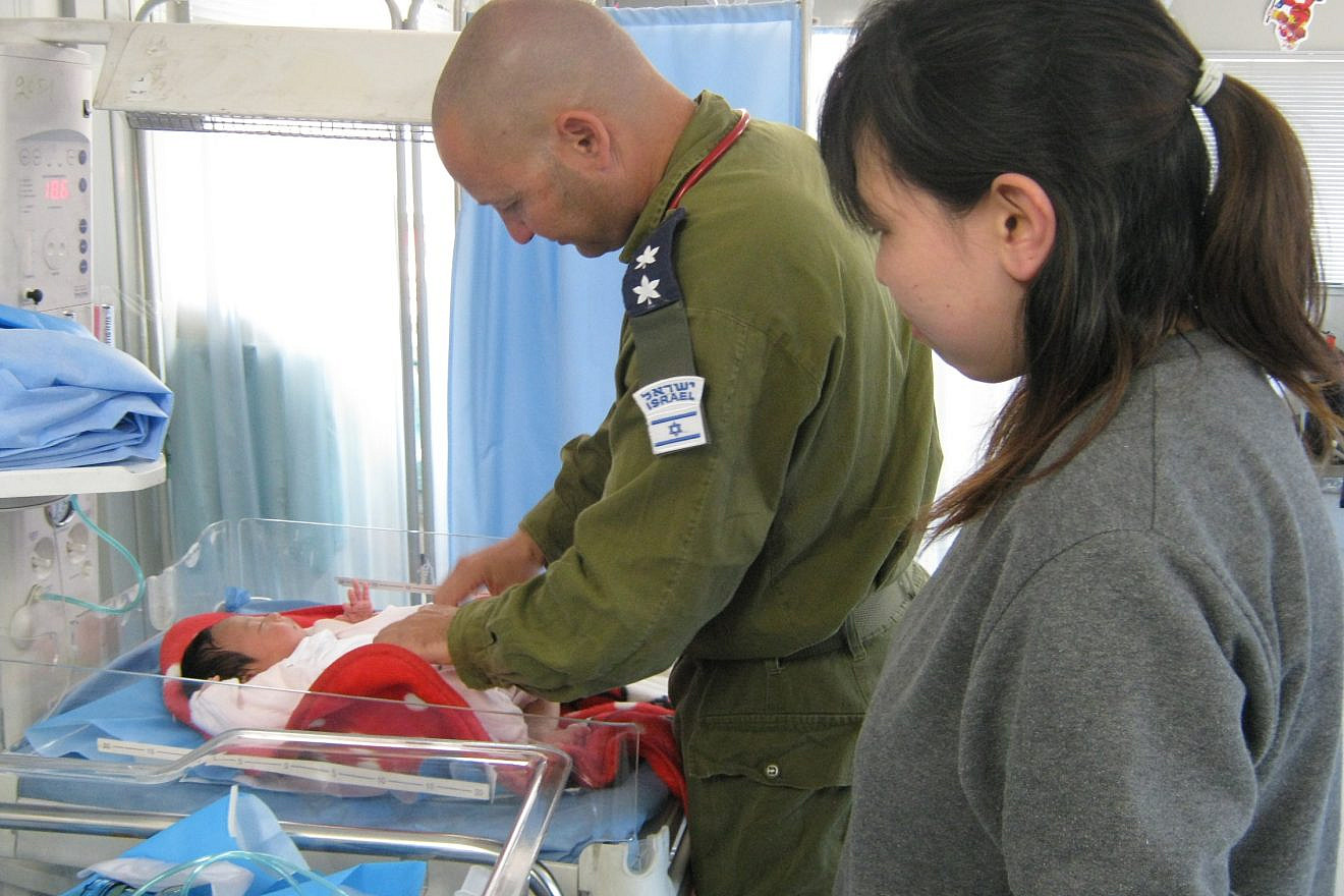 An Israeli army doctor treats a baby following the 2011 earthquake in Japan. Credit: Flickr.