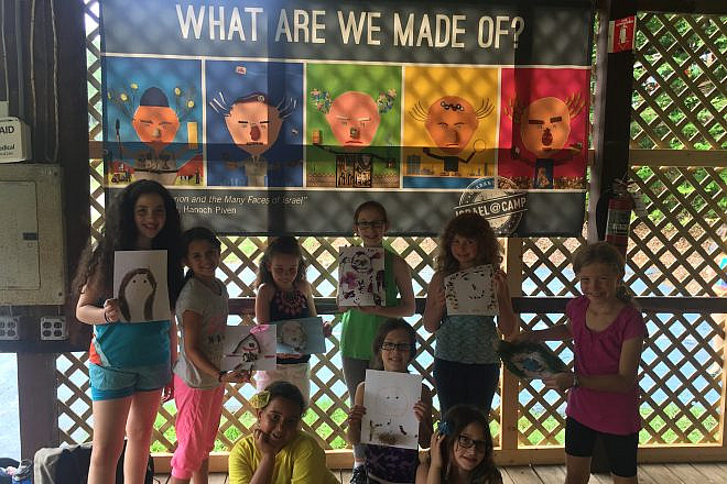 Campers show off their Hanoch Piven-inspired portraits in front of their Israel @ Camp banner. Credit: iCenter for Israel Education.