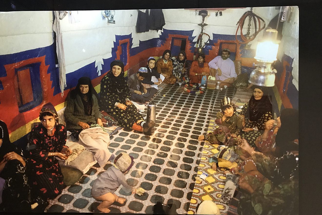 A Yemenite Jewish family in the multifunction room of their home, which would be used for sleeping, eating and entertaining. Photo from a 2018 exhibit in New York City. Credit: Shiryn Solny/JNS.