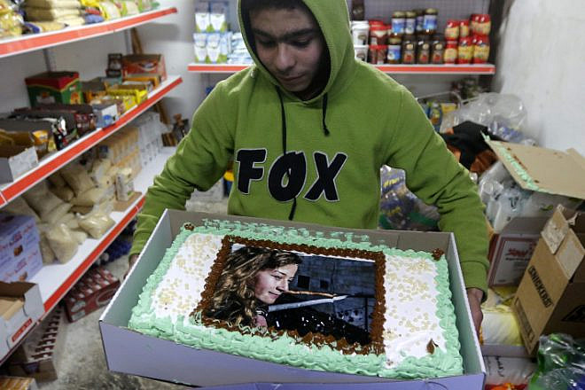 A Palestinian boy holds a cake with a picture of Ahed Tamimi during a protest rally in the city of Hebron on Jan. 30, 2018. Photo by Wisam Hashlamoun/Flash90.