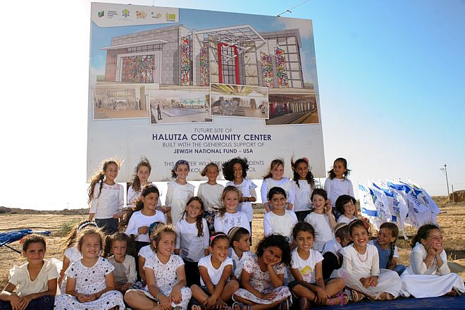 Children of Halutza sit in front of the site of the new state-of-the-art Halutza Community Center. Credit: Jewish National Fund-USA.