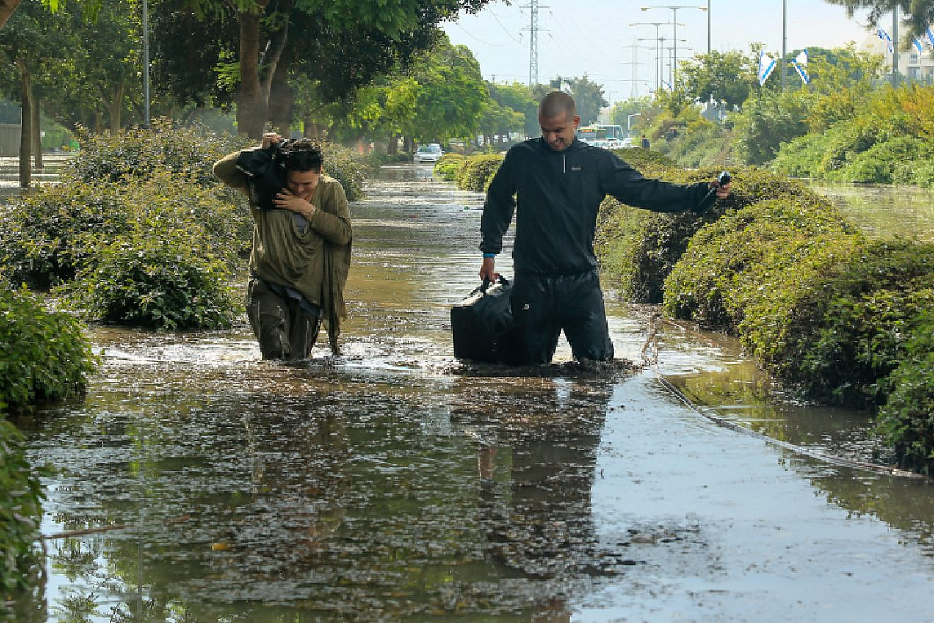 People try to wade through a flooded street after heavy rains in the southern Israeli city of Ashkelon on Nov. 9, 2015. Photo by Edi Israel/Flash90.