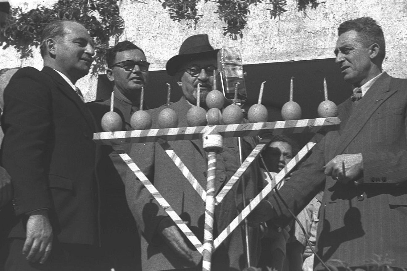 Chaim Weizman lighting a Hanukkah menorah at the Western Wall in Rehovot in 1948. Photo by David Eldan/GPO/Wikimedia Commons.