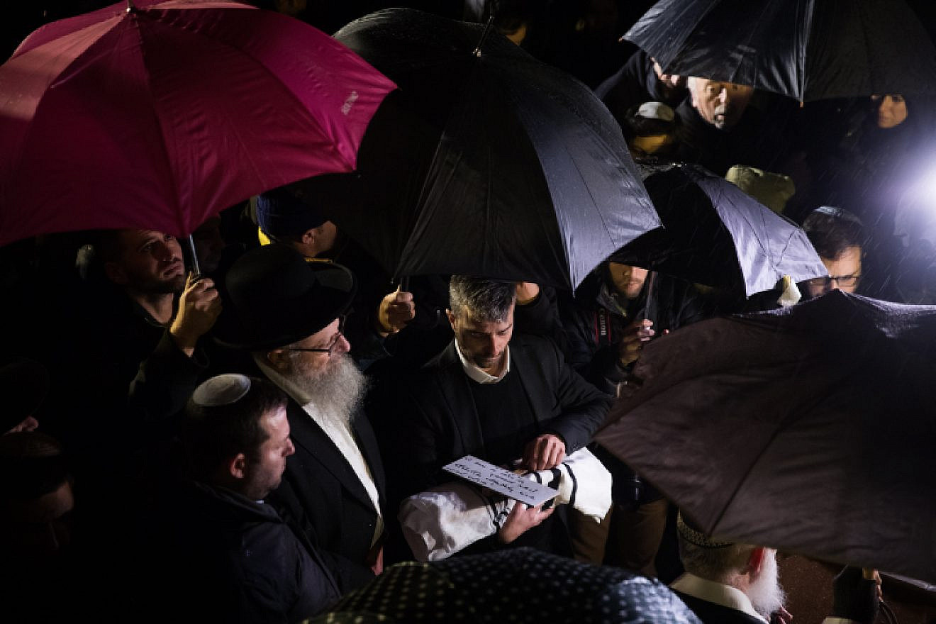 The 30-week-old son of Shira and Amichai Ish-Ran is cradled in a prayer shawl by his grandfather during his funeral at the Mount of Olives cemetery in Jerusalem on Dec. 12, 2018. Photo by Yonatan Sindel/Flash90.