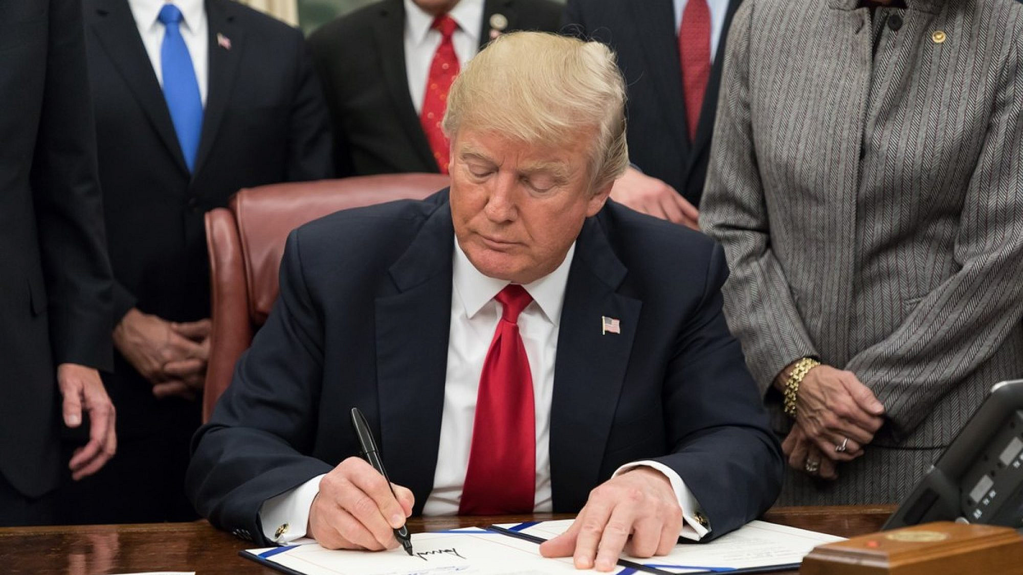 U.S. President Donald Trump signing legislation in the Oval Office, January 2018. Source: White House.