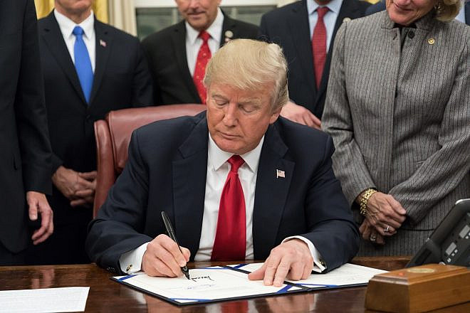 U.S. President Donald Trump signing legislation in the Oval Office, January 2018. Source: White House.