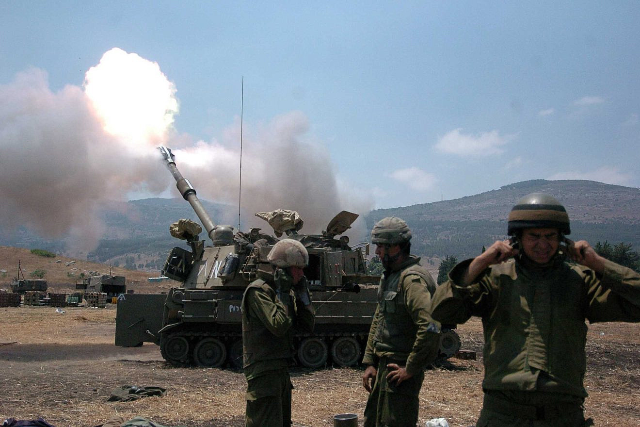 Israeli soldiers cover their ears as a tank fires into Lebanon from Kiryat Shmona on July 20, 2006, during the Second Lebanon War. Credit: Guy Assayag /Flash90.