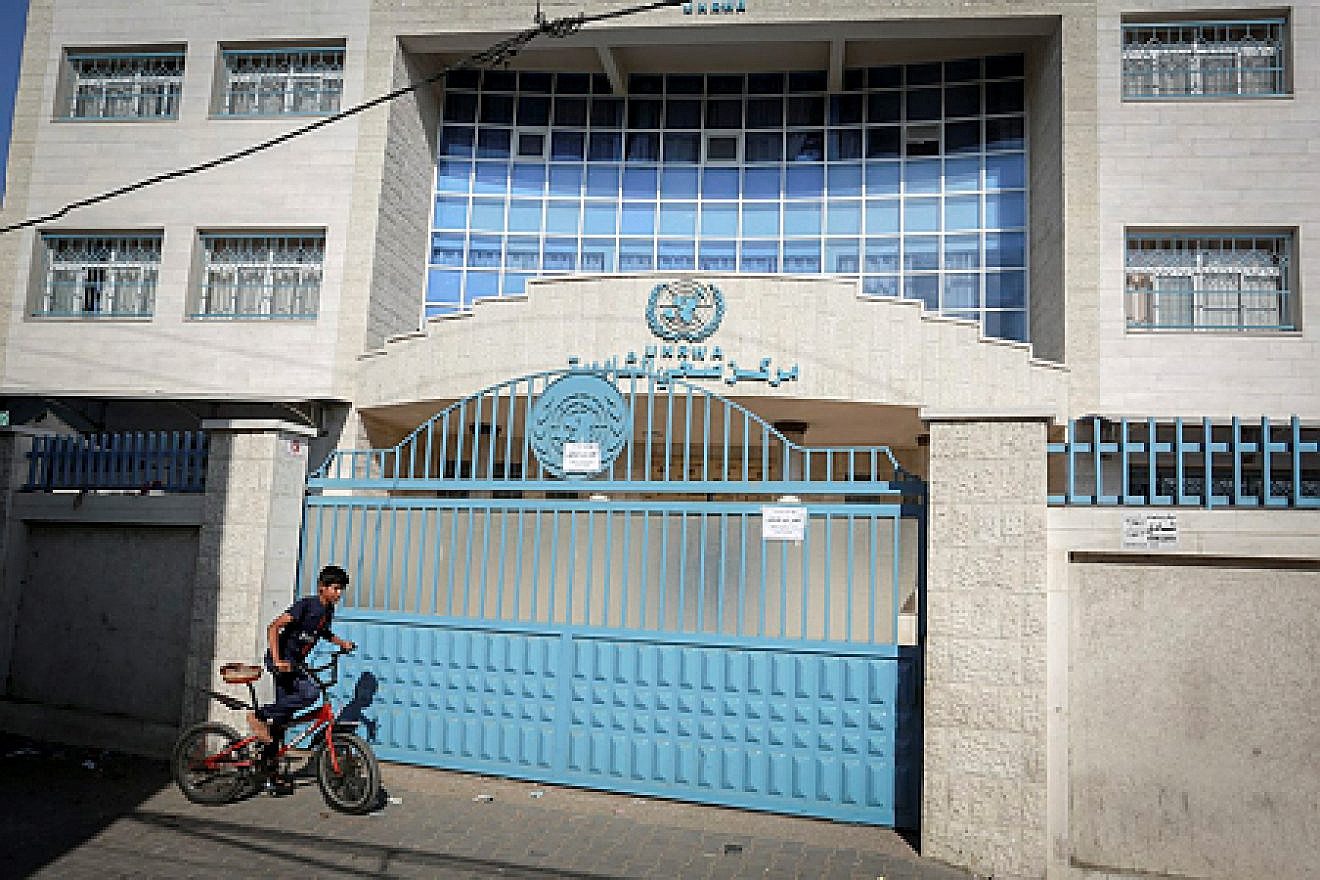 A Palestinian boy pedals by the closed offices of U.N. Relief and Works Agency for Palestine Refugees (UNRWA) during a strike of all UNRWA institutions in Rafah in the southern Gaza Strip on Sept. 24, 2018. Credit: Abed Rahim Khatib/Flash90.