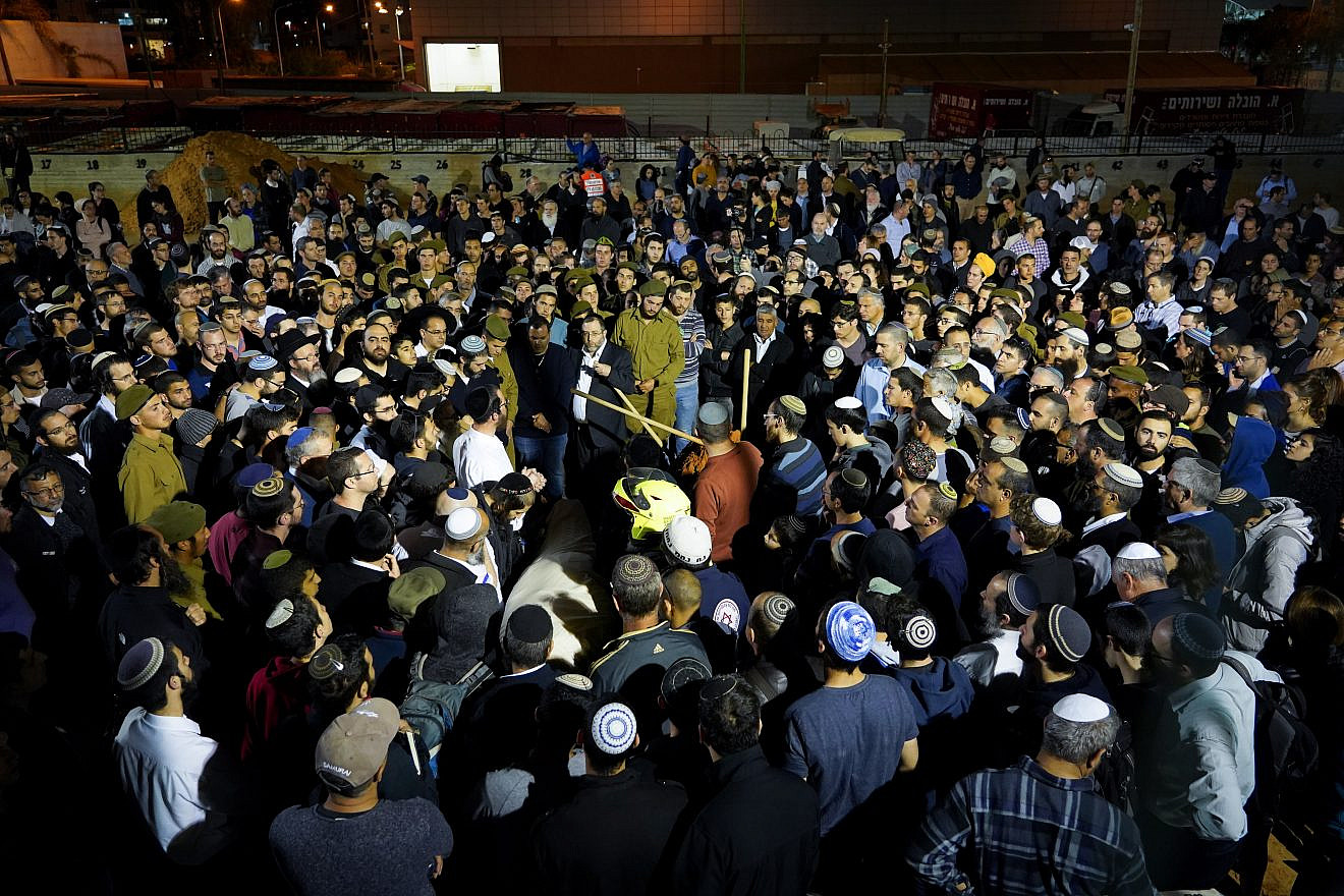 Family and friends carry the body of Rabbi Achiad Ettinger, 47, and a father of 12, who died after being shot in a terror attack near Ariel, during his funeral in Petach Tikvah, attended by more than 1,000 people on March 18, 2019. Photo by Hillel Maeir/Flash90.