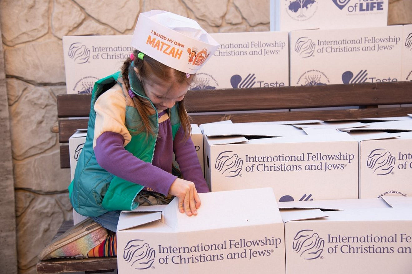 A young girl helps pack boxes containing food and other items to be sent to Jews in need. Credit: Federation of the Jewish Communities of the Commonwealth of Independent States.