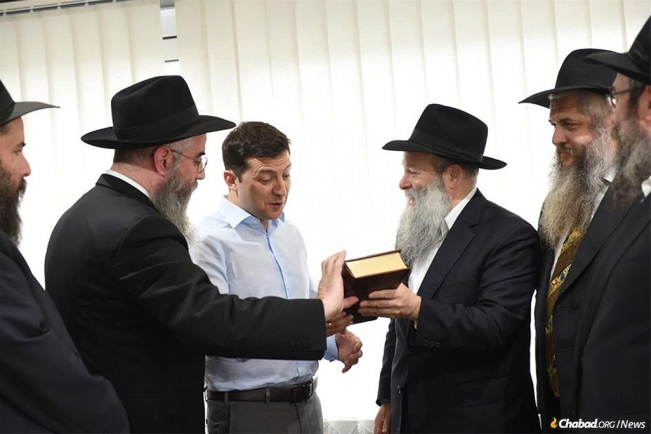 President-elect Volodymyr Zelenskyy, Ukraine's first-ever Jewish president, held a high-profile meeting with Ukraine's regional chief rabbis on May 6. Here, the comedian-turned-politician is presented with a Chumash in Russian translation by Rabbi Shmuel Kaminezki and Rabbi Avraham Wolff, as other members of the delegation look on. Credit: Chabad.org/News.