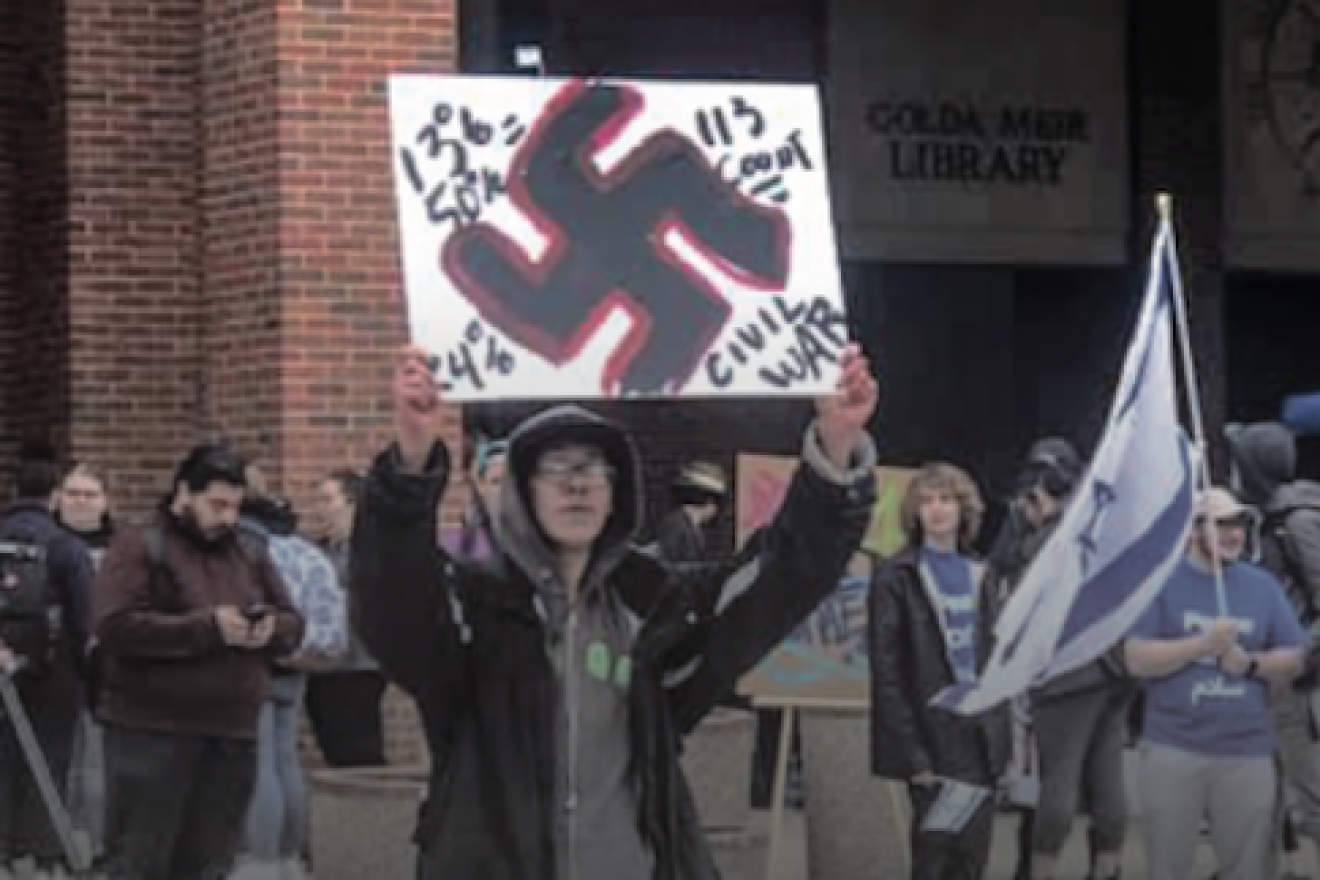 Kristian Gresham, 26, a student at the University of Wisconsin-Milwaukee protested an Israel Independence Day event with a sign consisting of a swastika and anti-Semitic messages, May 6, 2019. Credit: Change.org.