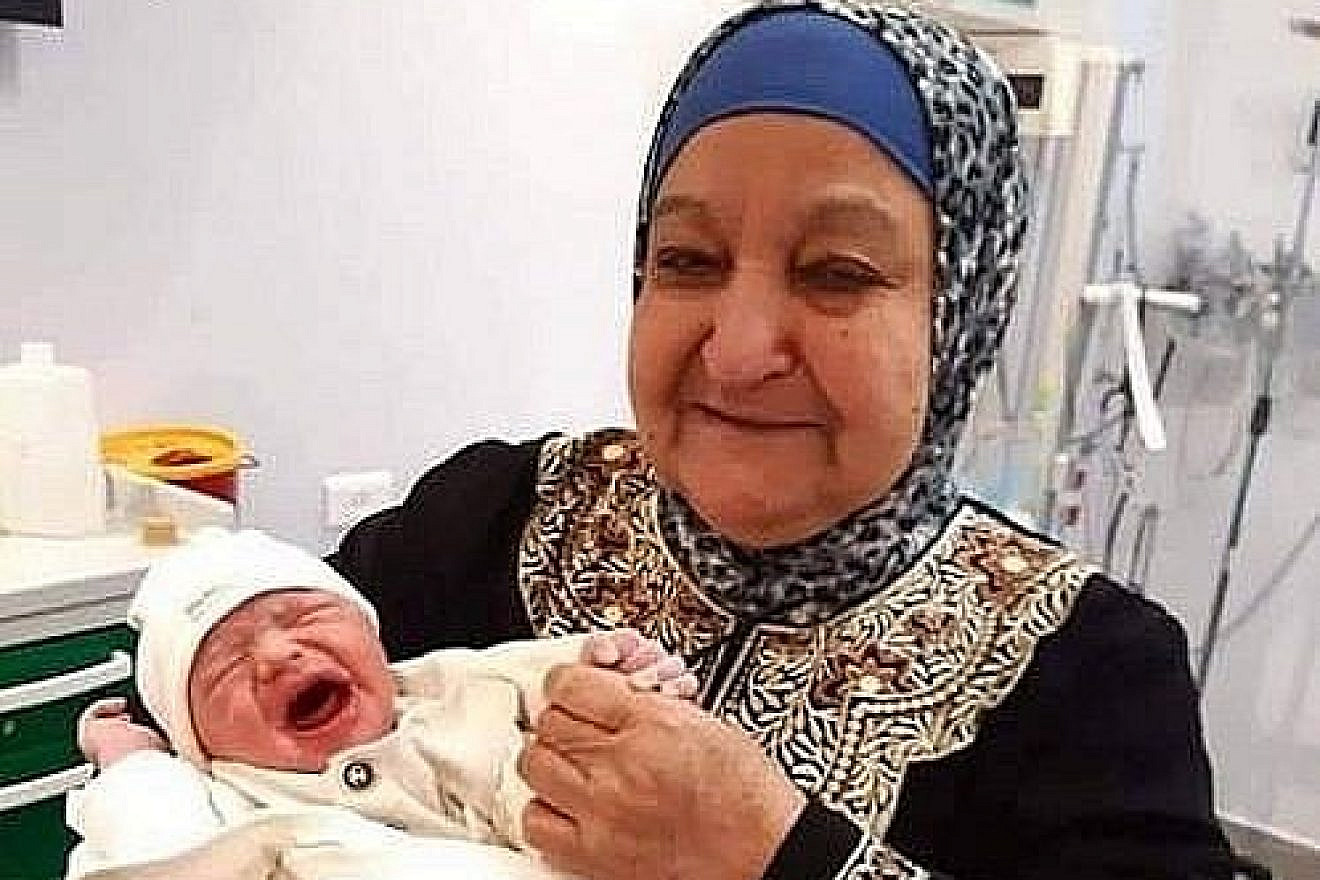 The text accompanying this image, which was posted to the official Fatah Facebook page on June 15, reads: “A child from smuggled sperm. The mother of prisoners and martyrs, Um Nasser Abu Hmeid, holds her grandson Yaman in her arms, the son of prisoner Nasr Abu Hmeid, who is serving five life sentences.” (PMW)