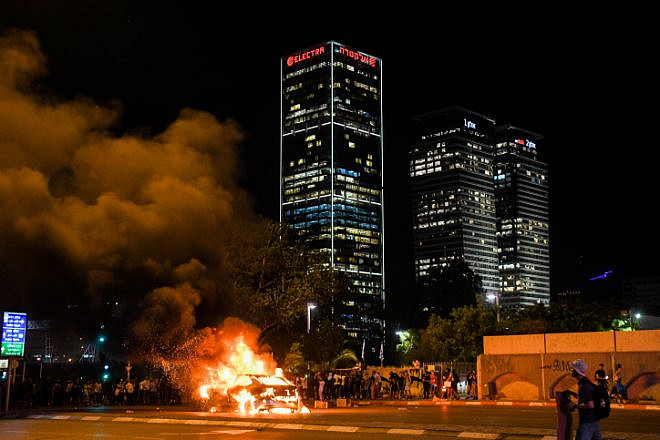A car is lit on fire in Tel Aviv during a protest over the June 30 shooting death of 19-year-old Ethiopian Solomon Tekah in Kiryat Haim, July 2, 2019. Photo by Flash90.