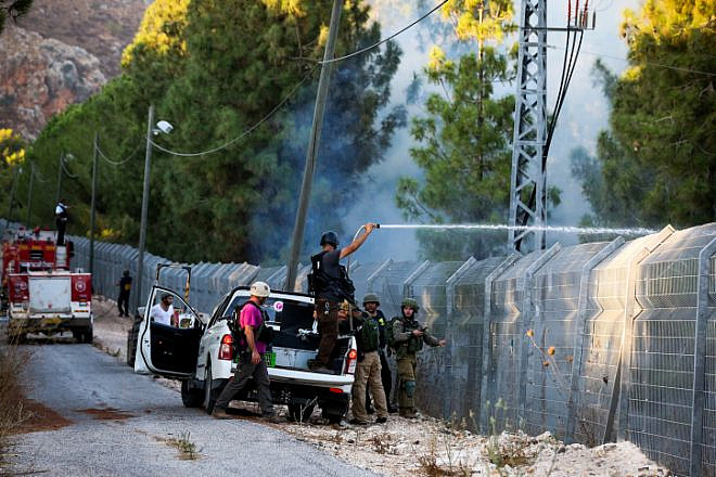 Israeli security forces try to extinguish a fire caused by a Hezbollah rocket launched from Lebanon near Moshav Avivim in the Galilee panhandle, Sept. 1, 2019. Photo by David Cohen/Flash90.