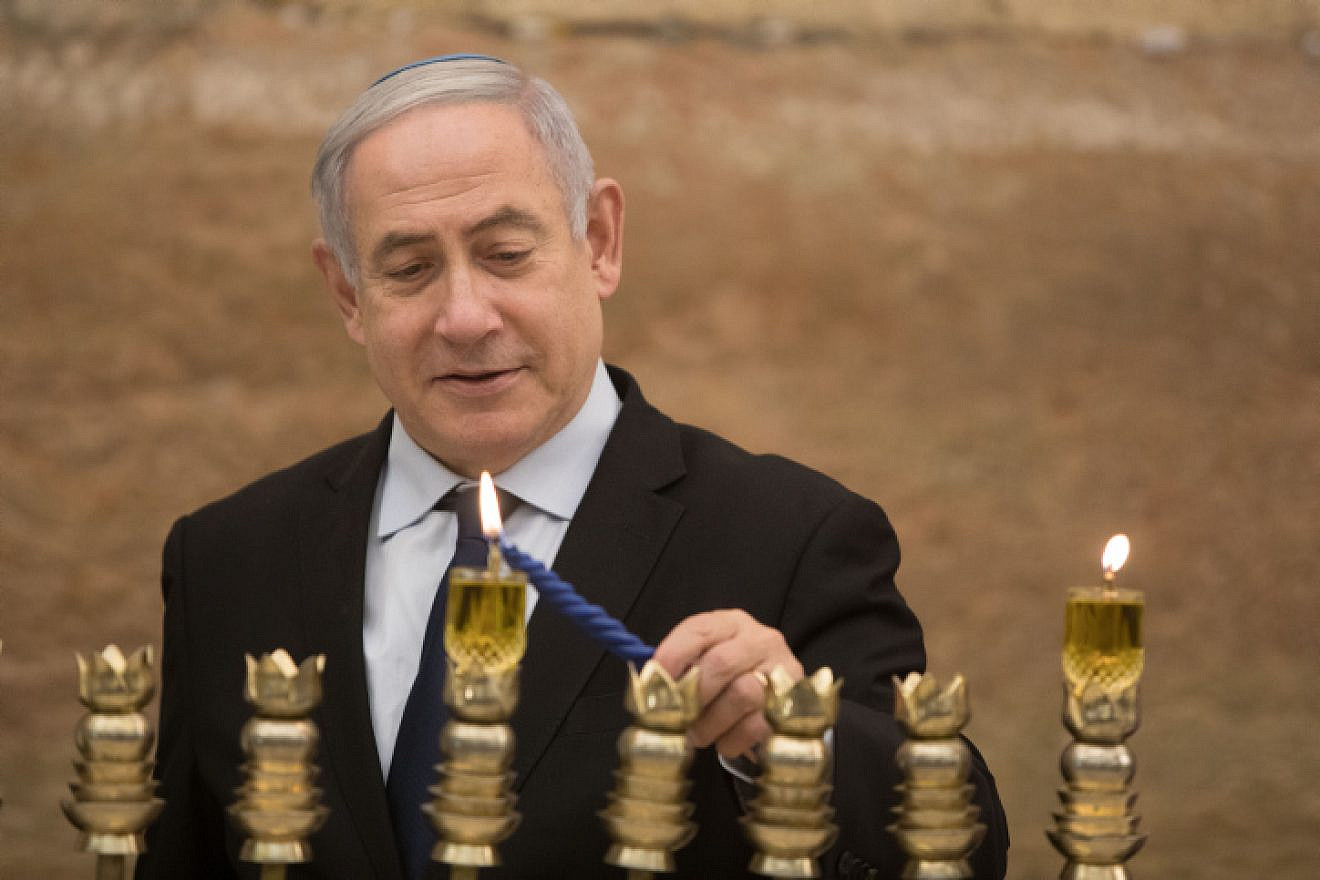 Israeli Prime Minister Benjamin Netanyahu lights a menorah on the first night of the Jewish holiday of Hanukkah at the Western Wall in Jerusalem's Old City on Dec. 22, 2019. Photo by Noam Revkin Fenton/Flash90.