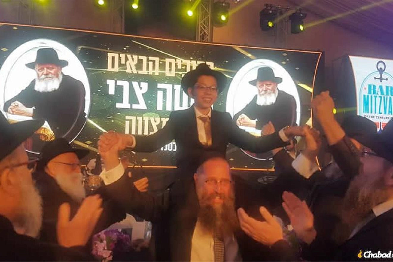 A celebratory bar mitzvah crowd dances with Moshe Holtzberg, orphaned in the Mumbai Chabad center massacre that took the lives of his parents 11 years ago this week. Credit: Chabad.org/News.