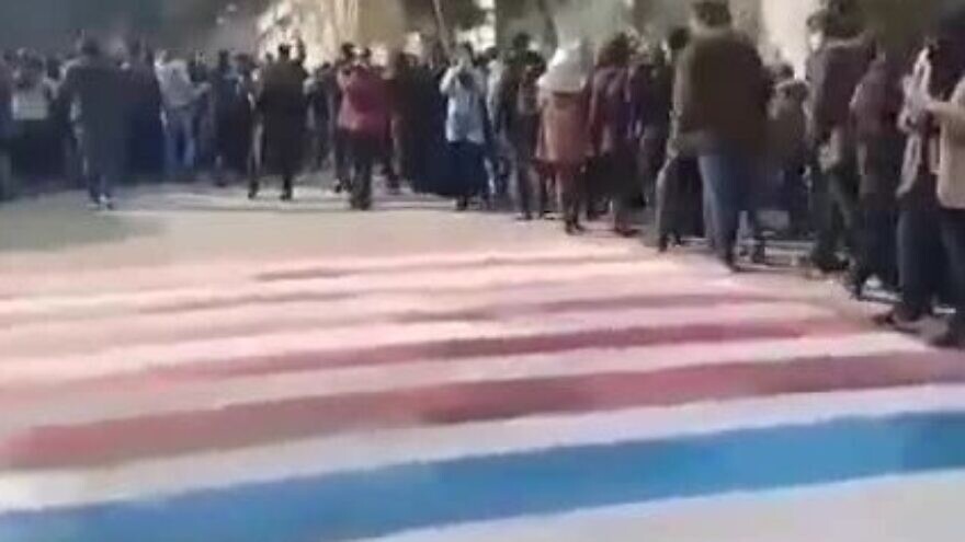 In this still image taken from a video clip, demonstrators at Shahid Beheshti University in Tehran can be seen walking around U.S. and Israeli flags, instead of over them, on Jan. 12, 2020. (MEMRI)