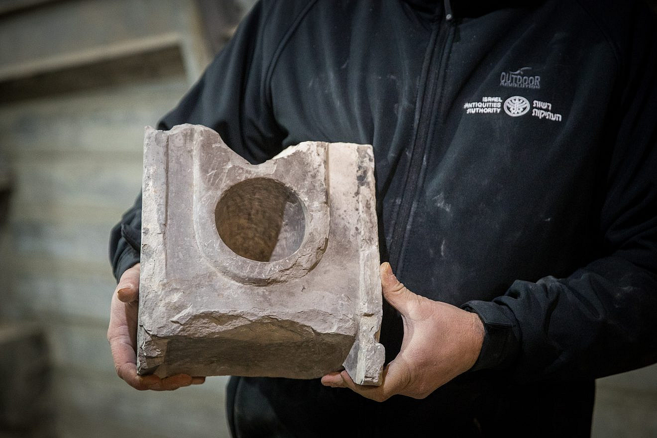 Israel Antiquities Authority Archaeologist Ari Levy holds a 2,000-year-old measuring table found near the Pilgrimage Road at the City of David in eastern Jerusalem on Jan. 6, 2020. Photo by Yonatan Sindel/Flash90.