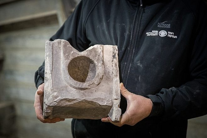 Israel Antiquities Authority Archaeologist Ari Levy holds a 2,000-year-old measuring table found near the Pilgrimage Road at the City of David in eastern Jerusalem on Jan. 6, 2020. Photo by Yonatan Sindel/Flash90.