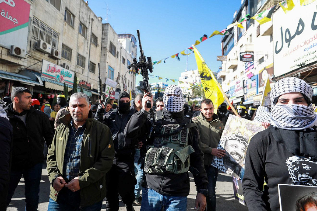 Palestinian Fatah members hold up their weapons during a rally marking the 55th anniversary of the founding of the Fatah movement, in the West Bank city of Ramallah, Dec. 31, 2019. Photo by Flash90.