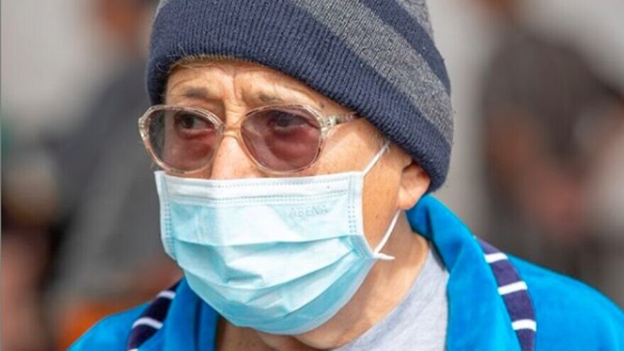 A senior citizen in Israel wearing a face mask to protect himself from the coronavirus, March 2020. Credit: Photo by Jordan Hay/IFCJ.