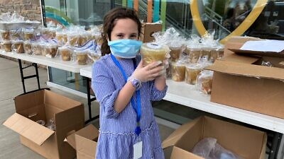 Liba Grossbaum displays the main item in “Challah and Chicken Soup for the Quarantined Soul” packages for Shabbat, distributed by the Friendship Circle in Livingston, N.J., May 1, 2020. Credit: Courtesy.