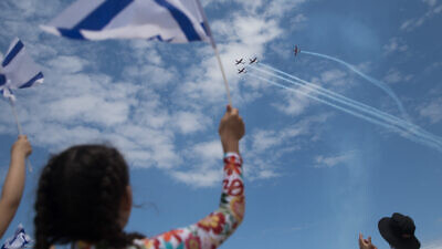 People at Bugrashov Beach in Tel Aviv watch the military airshow on Israel's 71st Independence Day, May 9, 2019. Photo by Hadas Parush/Flash90.
