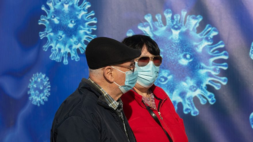 Passersby outside a COVID-19 vaccination center in Jerusalem, on Dec. 31, 2020.  Photo by Olivier Fitoussi/Flash90.