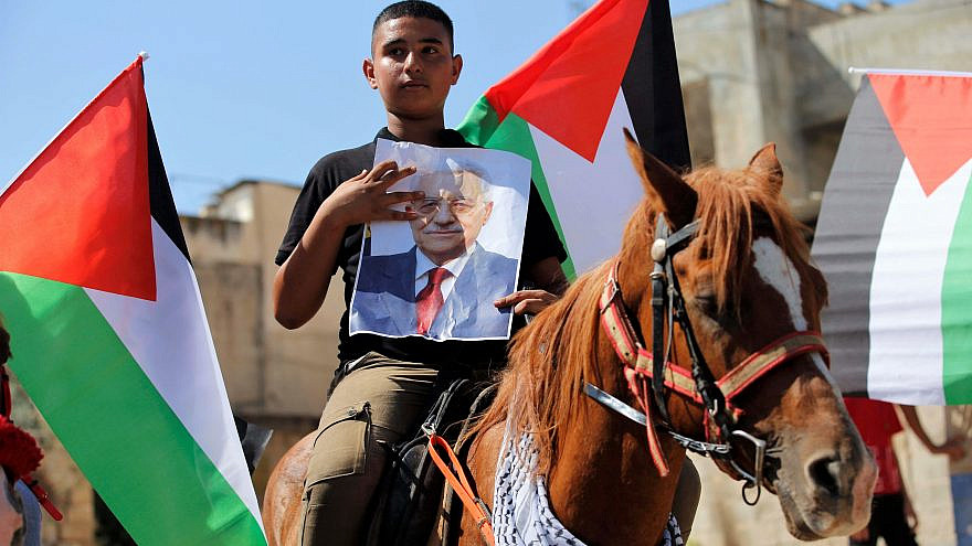 A Palestinian boy holds up a poster of Palestinian Authority leader Mahmoud Abbas in the West Bank town of Tubas. Sept. 27, 2020. Photo by Nasser Ishtayeh/Flash90.